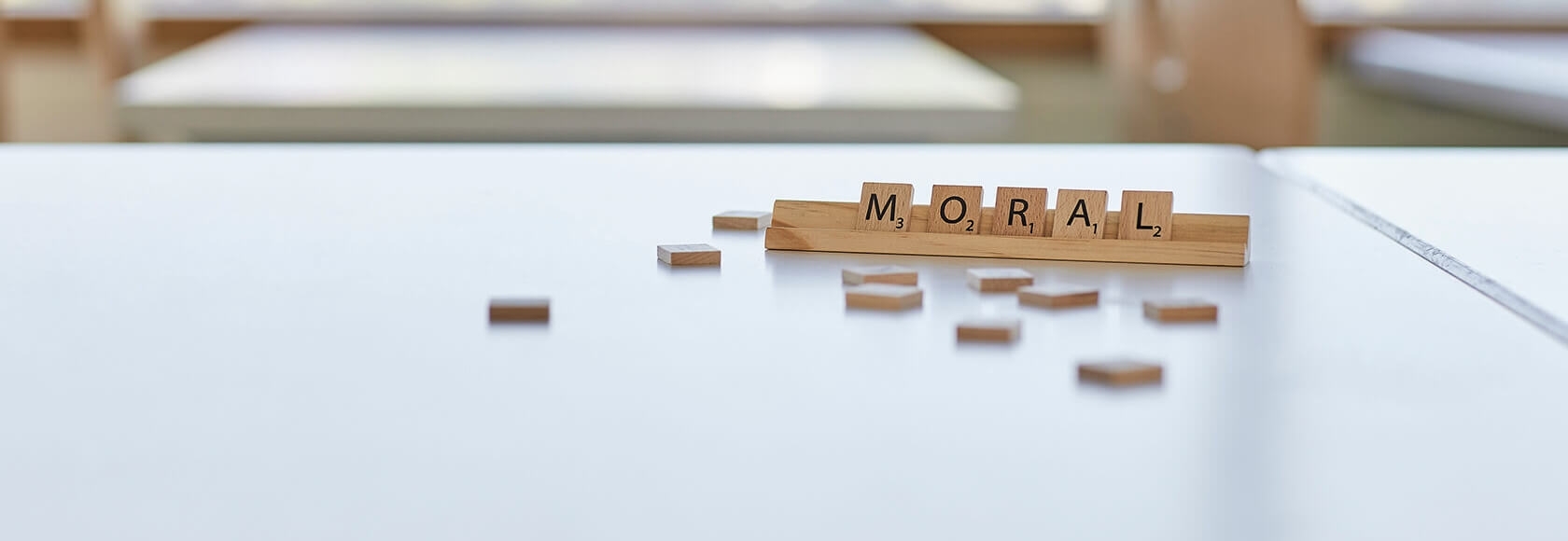 Einzelne Buchstabensteine, die auf einer Ablage das Wort "Moral" bilden